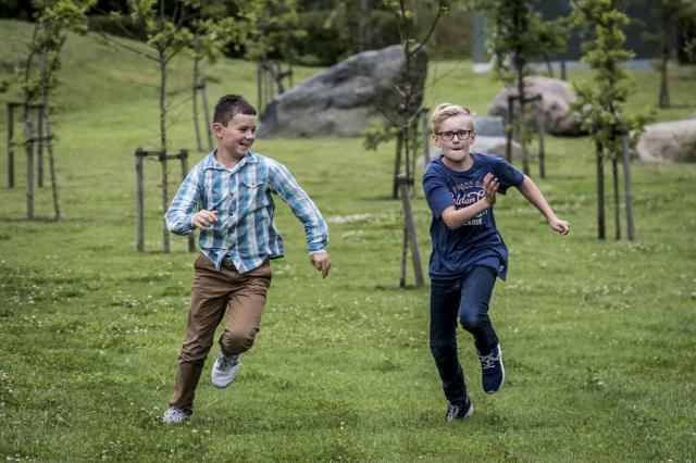 Drenge løber på græs